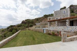 einem externen Blick auf ein Gebäude mit einem Hof in der Unterkunft Nature Villas Myrthios in Plakias