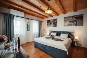 - une chambre avec un grand lit dans une pièce dotée de plafonds en bois dans l'établissement Kocbek since 1929, à Sveti Jurij ob Ščavnici