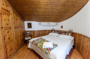 Schlafzimmer mit einem Bett mit Holzdecke in der Unterkunft Spazioso appartamento centrale con wi-fi in Cortina d'Ampezzo