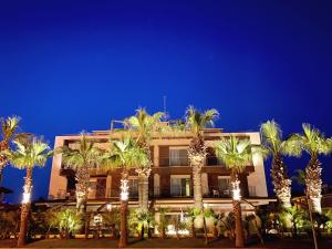 a building with palm trees in front of it at Kalyon Cesme in Cesme