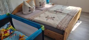ein Babybett mit einem Bett in einem Zimmer in der Unterkunft Fewo-Kreiensen in Einbeck