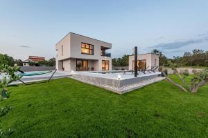 a house with a large yard with a swimming pool at Villa Rocinante ZadarVillas in Murvica