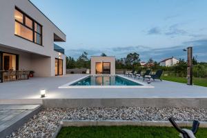 a swimming pool in the backyard of a house at Villa Rocinante ZadarVillas in Murvica