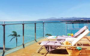 una terraza con una mesa y una silla sobre el agua en Arrecife Gran Hotel & Spa, en Arrecife