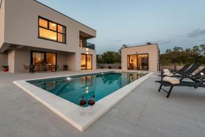 a swimming pool in the backyard of a house at Villa Rocinante ZadarVillas in Murvica +53 photos