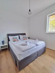 a bedroom with a large bed with white sheets and a window at Makach Apartments in Ohrid