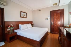 sypialnia z łóżkiem i drewnianymi drzwiami w obiekcie Van Ha Hotel w Ho Chi Minh