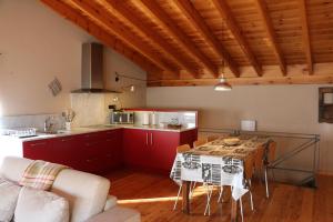 een keuken met rode kasten en een tafel in een kamer bij Cal Sastre in Pardines