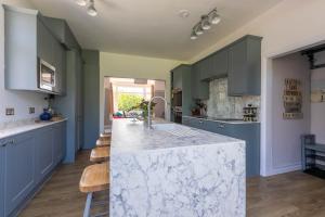 cocina con armarios azules y encimera blanca en Winterstoke View-Family&Dog Friendly Beach Retreat, en Ramsgate