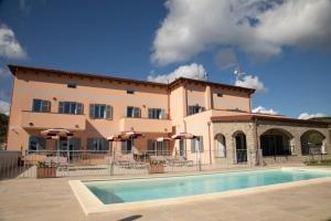 a large building with a pool in front of it at Antichi Ricordi - La Stalla in Molino Nuovo