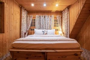 1 dormitorio con 1 cama en una habitación de madera en StayVista at Lavender Haze - 3BR Cottage, en Pahalgām