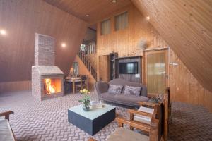a living room with a couch and a fireplace at StayVista at Lavender Haze - 3BR Cottage in Pahalgām +14 photos
