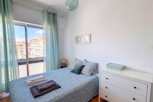 a bedroom with a bed with a dresser and a window at Cozy one bedroom apartment in Lisbon