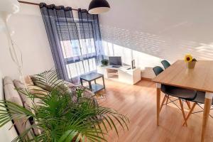 a living room with a table and a couch and a desk at Cozy one bedroom apartment in Lisbon