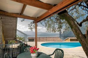 a patio with a table and chairs and a swimming pool at Casa Acqua in Riva di Solto