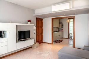 a living room with a television and a kitchen at Casa Acqua in Riva di Solto