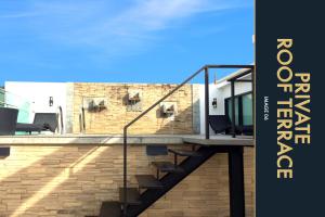 カマラビーチにある3 BR Amazing Condo with Private Rooftop Poolのレンガ造りの壁の前に階段がある建物