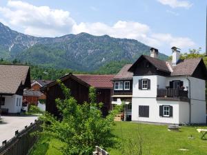 uma grande casa branca com montanhas ao fundo em Hexenhäuschen em Bad Goisern