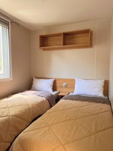 Un pat sau paturi într-o cameră la Mobil home camping 4 étoiles les Viviers 2 chambres