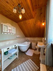 a bathroom with a tub and a sink and a toilet at Cozy family house in Odorín