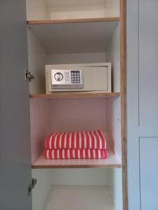 リヴィエール・ノワールにあるBois Mapou Self Catering Apartments Unit 201の電子レンジ、枕が備わる棚
