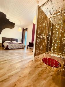 ein Schlafzimmer mit einem Bett und einer Wand mit Beleuchtung in der Unterkunft La Maison Bliss in Piolenc