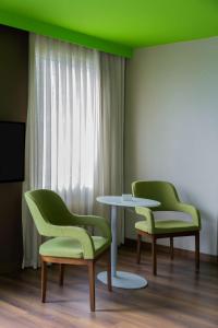 two chairs and a table in a room with a green ceiling at Park Inn by Radisson Istanbul Asia Kavacik in Istanbul