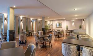 un restaurante con mesas, sillas, mesas y sillas en Radisson Blu Hotel, Letterkenny, en Letterkenny