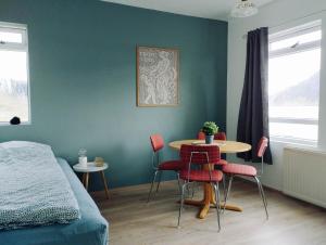 um quarto com uma cama, uma mesa e cadeiras em Bergistangi Guest House em Norðurfjörður