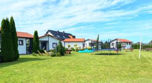 a yard with a ping pong table and houses at Domek Standard 2 in Darłowo