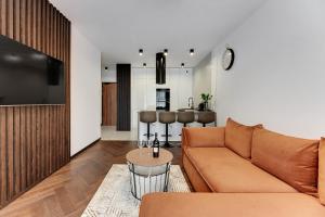 uma sala de estar com um sofá e uma mesa em Downtown Apartments Seaside Baltea Park & Parking em Gdansk