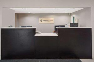 an office with a reception desk with a sign on the wall at Clarion Pointe Indianapolis Northeast in Castleton