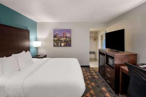 a hotel room with a bed and a flat screen tv at Clarion Pointe Indianapolis Northeast in Castleton