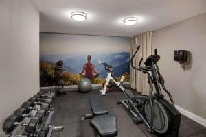 a room with a gym with a woman and bikes at Clarion Pointe Indianapolis Northeast in Castleton