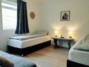 um quarto com 2 camas individuais e uma mesa em Bergistangi Guest House em Norðurfjörður
