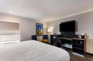 Habitación de hotel con cama, escritorio y TV. en Quality Inn South Bend near Notre Dame en South Bend