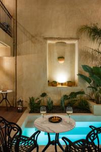 a patio with a table and two glasses of wine at Casa di Gaga Luxury Suites in Rethymno Town +44 photos
