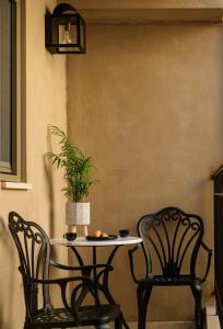 Dos sillas y una mesa con una planta. en Casa di Gaga, en Rethymno