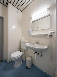 ein weißes Bad mit einem WC und einem Waschbecken in der Unterkunft Hotel Bristol in Luxemburg (Stadt)