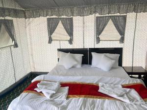a bedroom with two beds with white sheets and windows at The Sky Desert ,Hunder , Nubra in Charāsa