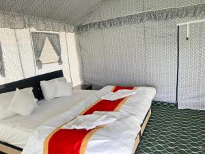 a bedroom with two beds with white and red sheets at The Sky Desert ,Hunder , Nubra in Charāsa +13 photos