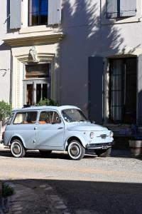 een kleine witte auto geparkeerd voor een gebouw bij La Souche Chambres et Table d'Hôtes in Saint-Chinian