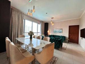 a dining room with a table and chairs and a couch at Durrani Homes - Grand 5BR besides Burj khalifa and Fountain view in Dubai