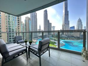 balcón con 2 sillas y vistas a la ciudad en Durrani Homes - Grand 5BR besides Burj khalifa and Fountain view en Dubái
