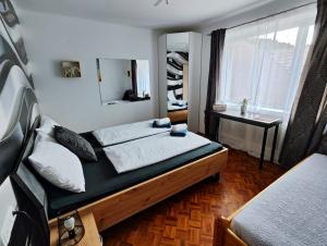 a bedroom with a bed and a desk and a window at ALPINpelso in Sankt Michael im Lungau