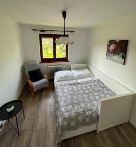 a bedroom with a bed and a chair and a window at Ubytování Sušice, Kašovice, Hrádek u Sušice in Hrádek