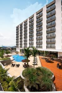 a large building with a swimming pool and a resort at Movich Hotel de Pereira in Pereira