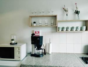 a kitchen with a coffee maker and a microwave at Gistiheimilið Bergistangi 1 in Norðurfjörður