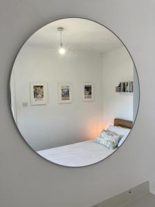 a bedroom with a bed and a mirror at 2a Coastguard Cottages in Gorran Haven