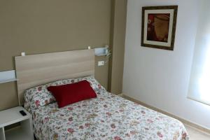 a small bedroom with a bed with a red pillow at Mi UNIVERSO in San Fernando